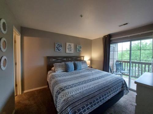 a bedroom with a bed and a large window at Placid Place Walk to Marina Fishing in Branson