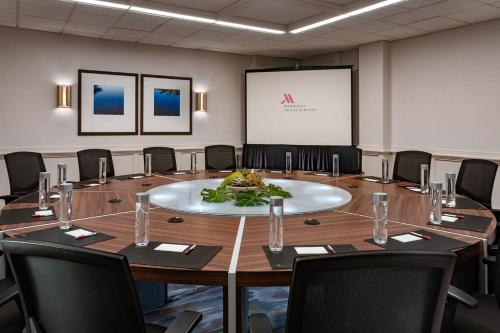 a conference room with a large table with chairs and a screen at Tampa Airport Marriott in Tampa