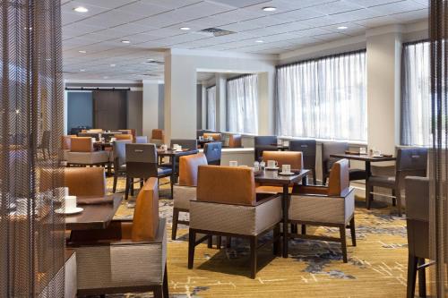 a dining room with tables and chairs and windows at Tampa Airport Marriott in Tampa