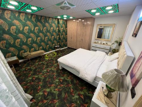 a bedroom with a large bed and a green wall at Three-bedroom Urban Retreat with Terrace AQZ Apartments in Humak