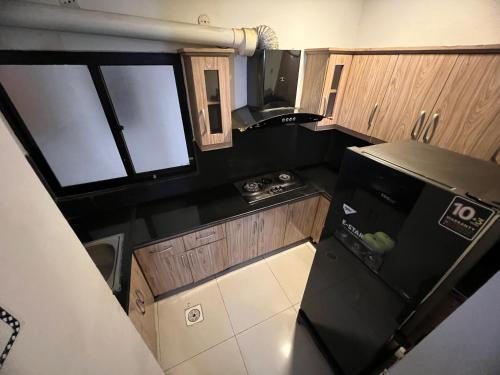 an overhead view of a small kitchen with a black refrigerator at Three-bedroom Urban Retreat with Terrace AQZ Apartments in Humak