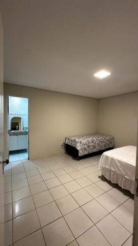 a bedroom with two beds and a tiled floor at Casa Porto Mar in Aracaju