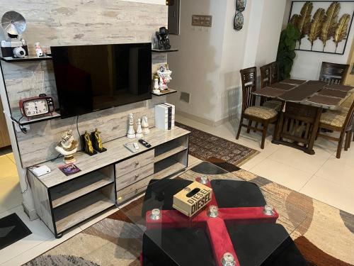 a living room with a entertainment center with a flat screen tv at Three-bedroom Urban Retreat with Terrace AQZ Apartments in Humak