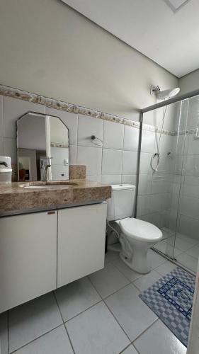 a bathroom with a toilet and a sink and a mirror at Casa Porto Mar in Aracaju