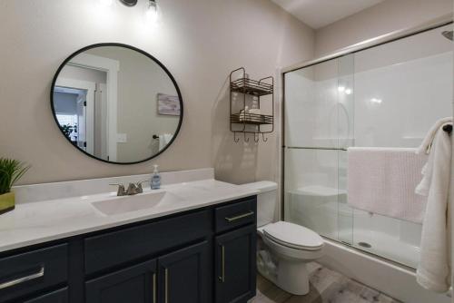 a bathroom with a sink and a toilet and a mirror at Journey's Remedy -Lake View Sleeps 30 in Branson