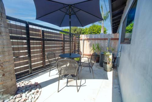 a patio with a table and chairs and an umbrella at Modern Ocean Beach Apartment in San Diego