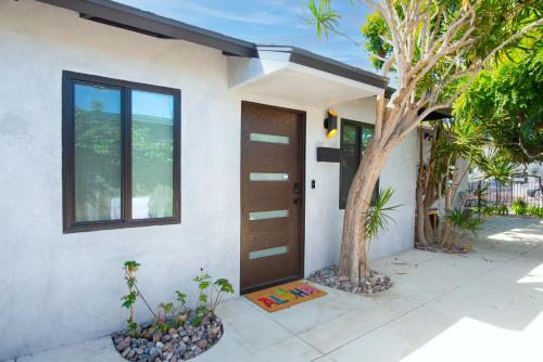 a door of a house with a tree next to it at Modern Ocean Beach Apartment in San Diego