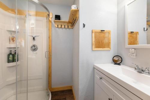 ein Badezimmer mit Dusche, Waschbecken und Toilette in der Unterkunft Historic Rockaway Beach Cottage in Rockaway Beach
