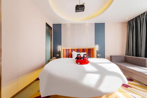 a bedroom with a large white bed and a couch at Yunyuexi Hotel - Guangzhou Baiyun Cengang Branch in Guangzhou