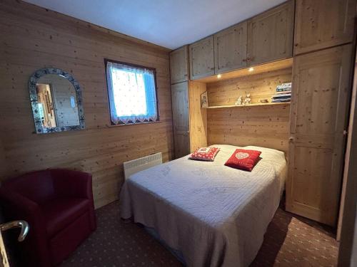 une chambre avec un lit et une chaise dedans dans l'établissement Charmant Appartement Méribel - 2 Pièces, Cabine, Balcon Sud, Casier à Skis - FR-1-355-266, à Les Allues