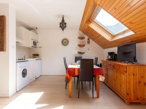 une cuisine avec une table et des chaises ainsi qu'une fenêtre dans l'établissement Appartement cosy pour 4 à Saint Lary village, proche pistes - FR-1-296-503, à Saint-Lary-Soulan