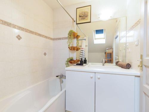 La salle de bains blanche est pourvue d'un lavabo et d'une baignoire. dans l'établissement Appartement cosy pour 4 à Saint Lary village, proche pistes - FR-1-296-503, à Saint-Lary-Soulan