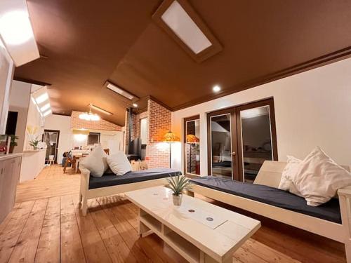 a living room with a large bed and a table at トラストメゾン一碧湖 in Ogi
