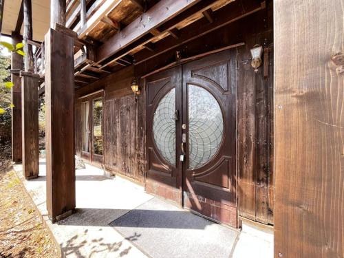a wooden door with a circle in the middle at トラストメゾン一碧湖 in Ogi