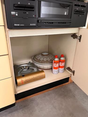 a kitchen cabinet with a microwave and a stove at トラストメゾン一碧湖 in Ogi