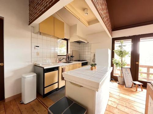 a kitchen with a counter top and a refrigerator at トラストメゾン一碧湖 in Ogi
