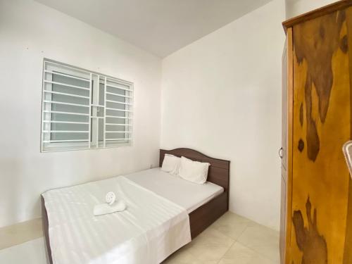 a bedroom with a bed with a white sheets and a window at Oceanus MT Vien Trieu Thai Ha Hotel & Apartment in Nha Trang