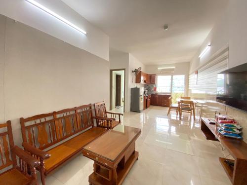 a living room with a couch and a table and chairs at Oceanus MT Vien Trieu Thai Ha Hotel & Apartment in Nha Trang
