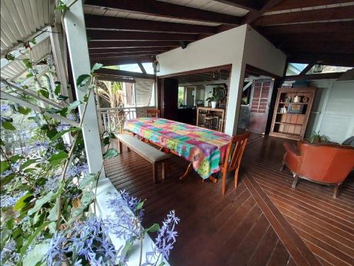 a deck with a bed and a table and chairs at Villa Créolia in Saint-Leu