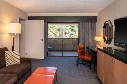 a hotel room with a couch and a television and a living room at Sheraton Mission Valley San Diego Hotel in San Diego