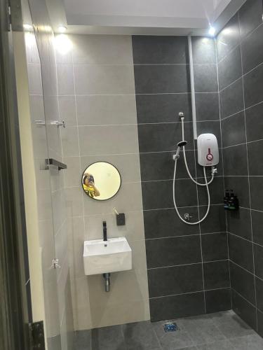 a bathroom with a sink and a shower at Jenny Homestay in Teluk Intan