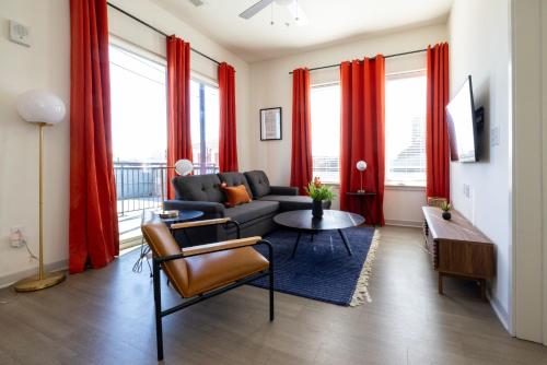 a living room with red curtains and a couch at Modern Nulu 2BR by CozySuites 04 in Louisville