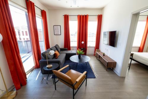 a living room with red curtains and a couch at Modern Nulu 2BR by CozySuites 04 in Louisville