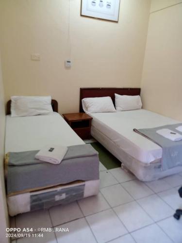 two beds sitting in a room with at perfect class hotel in Kuala Lumpur