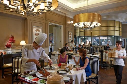 a chef preparing food at a table in a restaurant at Mandarin Oriental, Kuala Lumpur in Kuala Lumpur