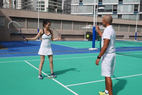 a man and a woman standing on a tennis court at Mandarin Oriental, Kuala Lumpur in Kuala Lumpur