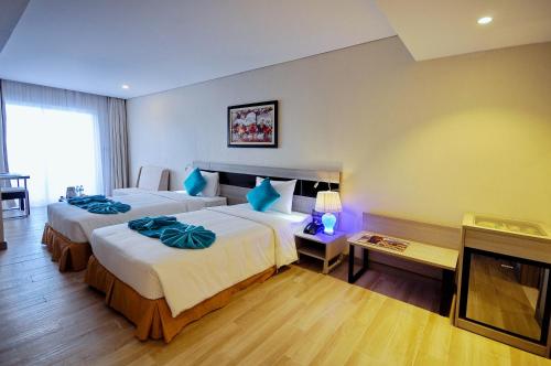 a hotel room with two beds and a television at Oceanus MT Vien Trieu Thai Ha Hotel & Apartment in Nha Trang
