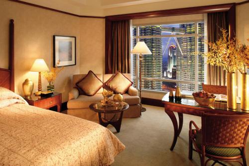 a bedroom with a bed and a desk and a couch at Mandarin Oriental, Kuala Lumpur in Kuala Lumpur
