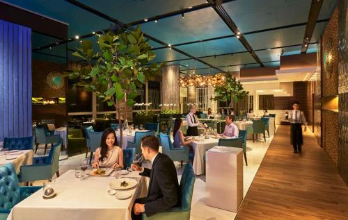 a group of people sitting at tables in a restaurant at Mandarin Oriental, Kuala Lumpur in Kuala Lumpur
