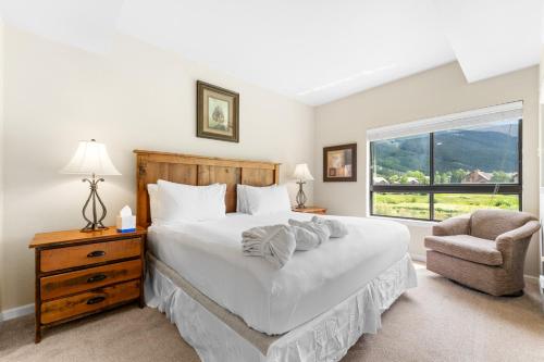 Un dormitorio con una cama, una silla y una ventana en Greens at Copper 219 by Summit County Mountain Retreats, en Copper Mountain