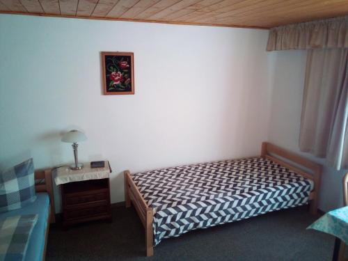 a small bedroom with a bed and a night stand at Zur Schlinge in Siebenhitz
