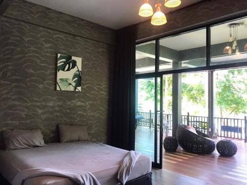 Un dormitorio con una cama en una habitación con ventanas. en 66 Baanaisuan 66 บ้านในสวน, en Ban Komo Sam Sip Paet