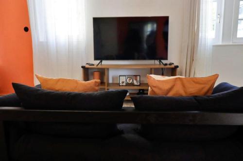 un salon avec un canapé et une télévision à écran plat dans l'établissement Liz Suite - T2 - Wifi - Queen size, à Rouen