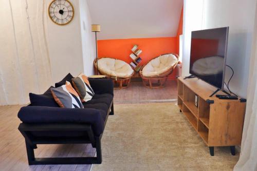 un salon avec un canapé et une télévision dans l'établissement Liz Suite - T2 - Wifi - Queen size, à Rouen