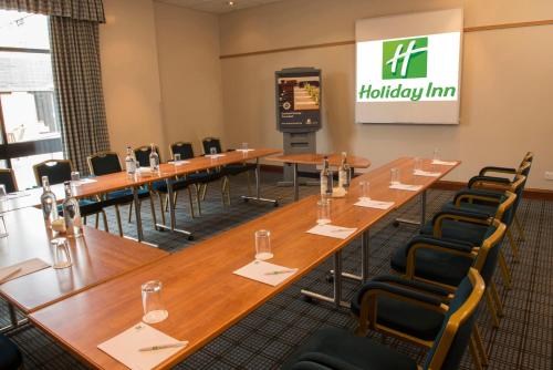 a conference room with long tables and chairs at Holiday Inn Brentwood by IHG in Brentwood