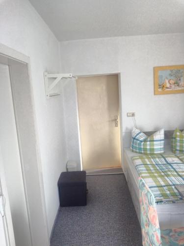 a bedroom with a bed and a door with a suitcase at Zur Schlinge in Siebenhitz
