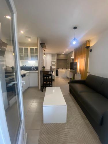 un salon avec un canapé et une table et une cuisine dans l'établissement La romance 19, à Maintenon