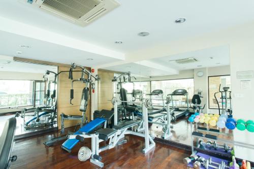 a gym with treadmills and machines in a room at Thomson Residence Hotel in Bangkok