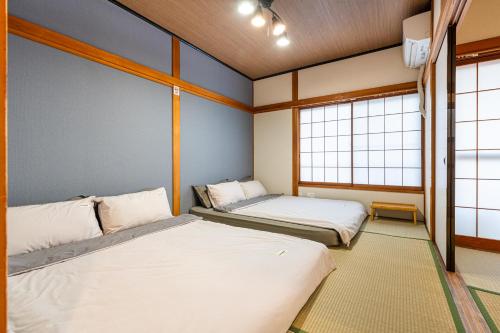two beds in a room with two windows at 晴空民宿 Sora House 晴空塔徒步圈 整栋出租 in Tokyo