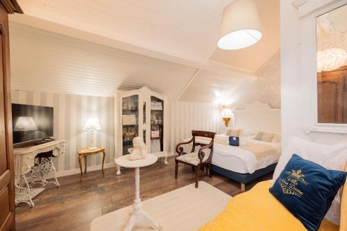 a bedroom with a bed and a desk and a tv at VILLA NOTRE DAME face au Château fort in Sedan