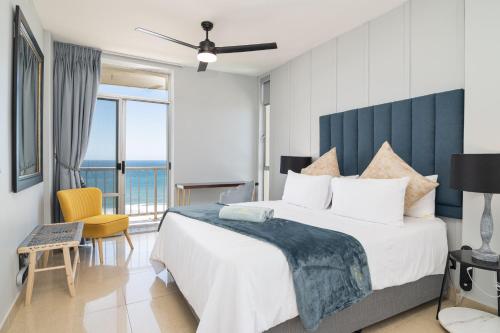 a bedroom with a large bed with a view of the ocean at Coastal View @ 1304 La Ballito in Ballito