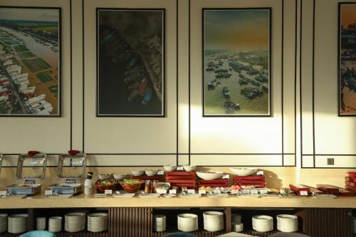 a display of dishes and bowls on a shelf with pictures at Charmant Suites a Boutique Hotel Can Tho in Can Tho