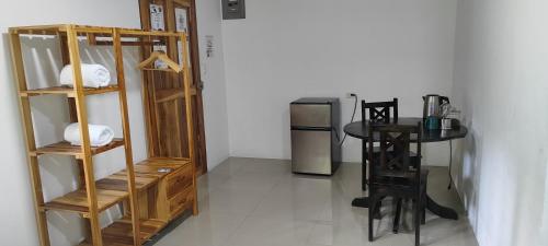 a room with a small table and a refrigerator at Casa Osa Azul in Puerto Jiménez