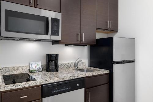 a kitchen with a sink and a refrigerator at TownePlace Suites by Marriott Fort Walton Beach-Eglin AFB in Fort Walton Beach