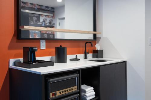 a kitchen with a black and white stove and sink at Aloft Orlando Lake Nona in Orlando