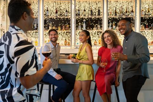 a group of people sitting around a bar drinking wine at Aloft Orlando Lake Nona in Orlando